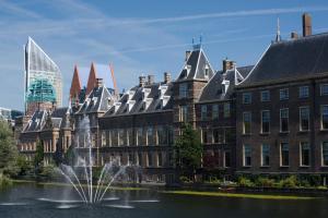 une fontaine en face des bâtiments et d'une ville dans l'établissement Fletcher Stadshotel Den Haag, à La Haye