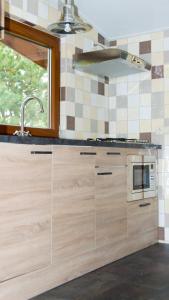 a kitchen with wooden cabinets and a microwave at Vrijstaande blokhut in Egmond-Binnen