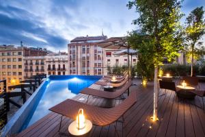 taras na dachu ze stołami i krzesłami oraz basenem w obiekcie Ocean Drive Barcelona w Barcelonie