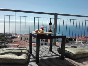 a table with a bottle of wine on a balcony at Zen Caniço Apartment in Caniço