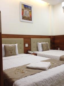 クイニョンにあるAu Lac Hotelのタオルが敷かれたベッドが2つあるホテルの部屋