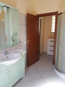 W łazience znajduje się umywalka i lustro. w obiekcie Appartamenti Via La Marmora w mieście Teulada