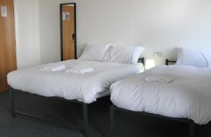 two beds sitting next to each other in a room at Mojitos Group Weekends Blackpool in Blackpool