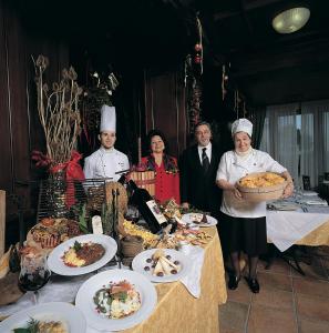 eine Gruppe von Menschen, die um einen Tisch mit Essen stehen in der Unterkunft Fattoria Paradiso in Bertinoro