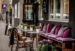 a row of benches with purple pillows on a building at Lilla Rådmannen in Stockholm