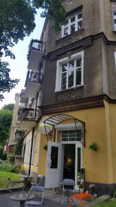 Un edificio con sillas y mesas delante. en Apartament Błonia, en Szczecin