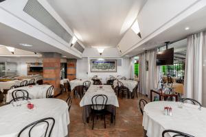 a dining room with white tables and chairs at Hotel Tevere Perugia in Perugia