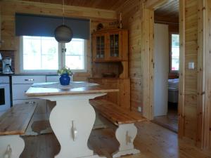 a kitchen with a table and a bench in a cabin at Cottage Kivitatti in Sysmä