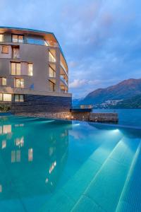 ラーリオにあるLaglio Como Lake Resortの建物の前にあるホテルのスイミングプール