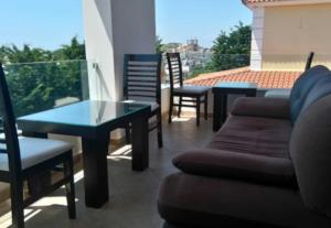 a living room with a table and chairs on a balcony at Villa Xristos Kalogeris in Ksamil