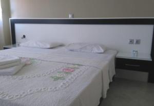 a bedroom with a bed with a white bedspread and a table at Villa Xristos Kalogeris in Ksamil