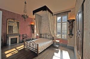 - une chambre avec un lit à baldaquin et une cheminée dans l'établissement Château de Gerbe, à Saint-Rémy-en-Rollat
