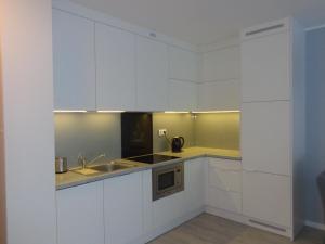 ポゴジェリツァにあるMorski22の白いキャビネットとシンク付きのキッチン