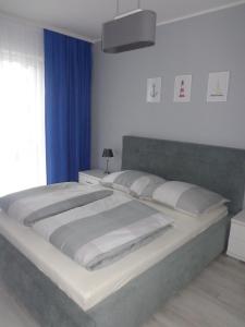 ポゴジェリツァにあるMorski22のベッドルーム1室(青いカーテン付きの大型ベッド1台付)