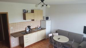 a small kitchen with a table and a counter at Golem Tatranská Štrba in Tatranska Strba