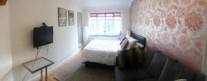um pequeno quarto com uma cama e uma televisão em Albemarle Apartment em Bromley