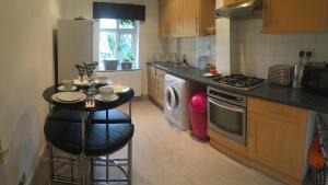 a kitchen with a small table in the middle of it at Albemarle Apartment in Bromley