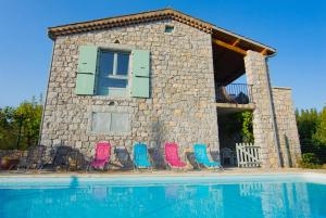 een groep stoelen en een huis met een zwembad bij Les 23 Mûriers in Chauzon