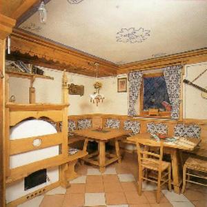 uma sala de jantar com uma mesa e uma mesa e cadeiras em Garni La Rondine em Selva di Cadore