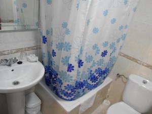 ein Badezimmer mit Waschbecken, Toilette und Duschvorhang in der Unterkunft Hostal Internacional in Madrid