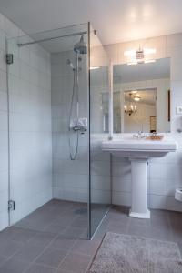 a bathroom with a sink and a shower at Kronen Gaard Hotel in Sandnes