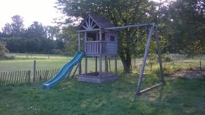 un parque infantil con un tobogán en un patio en Farm Stay Luythoeve, en Meeuwen