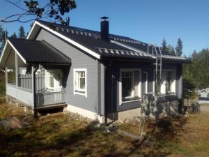 een klein huis met een zwart dak bij Vaaranpään loma-asunto in Vuokatti