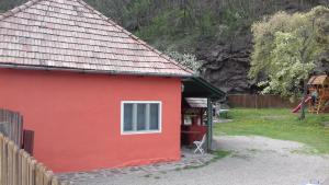 プライドにあるAmalia Vendégházの白窓と柵の赤い家