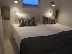 two beds in a room with white sheets and pillows at Cozy Cottage Near Geysir in Reykholt