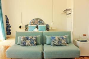a blue couch with pillows in a living room at Alojamentos Vista Mar-Luisa Todi in Setúbal