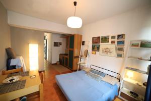 タオルミーナにあるSpisoneの青いベッド1台、デスクが備わる小さな客室です。