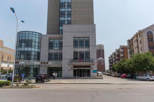 a building on a street with cars parked in front of it at Jinjiang Inn Tianjin South Railway Station in Tianjin