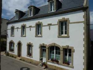 een groot wit gebouw met ramen aan een straat bij Chambres de la Ville d'Ys in Cléden-Cap-Sizun