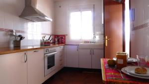 a kitchen with white cabinets and a window and a table at Lagunilla Rural in Fuente de Piedra