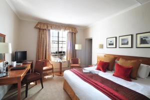 a hotel room with a bed and a desk and a computer at The White Lion Hotel in Aldeburgh