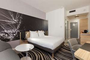 Novotel Tours Centre Gare في تور: غرفة فندقية بسرير وطاولة وكراسي