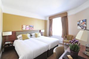 a hotel room with a large bed and a desk at The White Lion Hotel in Aldeburgh