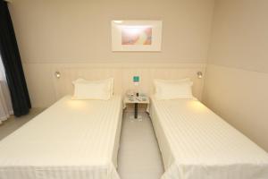 Cama ou camas em um quarto em Jinjiang Inn Tianjin South Railway Station