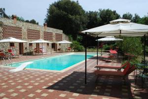a pool with a table and chairs and an umbrella at Agriturismo San Vettore in Gambassi Terme