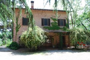 an old house with trees in front of it at Agriturismo San Vettore in Gambassi Terme