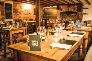 a dining room with wooden tables and wine glasses at White Horse & Griffin in Whitby
