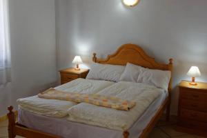 1 cama en un dormitorio con 2 mesitas de noche y 2 lámparas en Adega Mourato, en Bandeiras