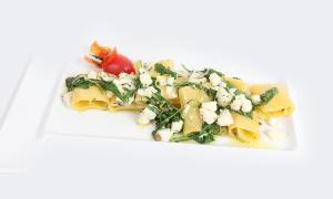 a plate of pasta with greens and cheese on it at Hotel Capizzo in Ischia