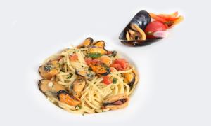 a plate of pasta with shrimp and other foods at Hotel Capizzo in Ischia