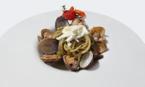 a plate of food with mussels and noodles at Hotel Capizzo in Ischia