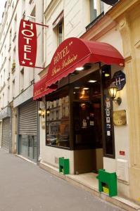 un restaurante con una sombrilla roja en una calle en Hôtel Paris Voltaire, en París