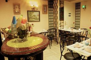 a restaurant with tables and chairs and a vase of fruit at Hôtel Paris Voltaire in Paris