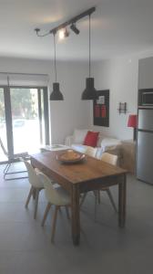 ナフプリオにあるPalamidi view newly constructed apartmentのリビングルーム(木製テーブル、椅子付)