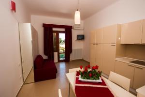 een keuken en een woonkamer met een tafel met bloemen erop bij Appartamenti via del Mare in Porto dʼAscoli