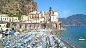 a bunch of umbrellas on a beach in front of a mountain at Vicolo 23 1 Minutes to Beach and Square Atrani in Atrani